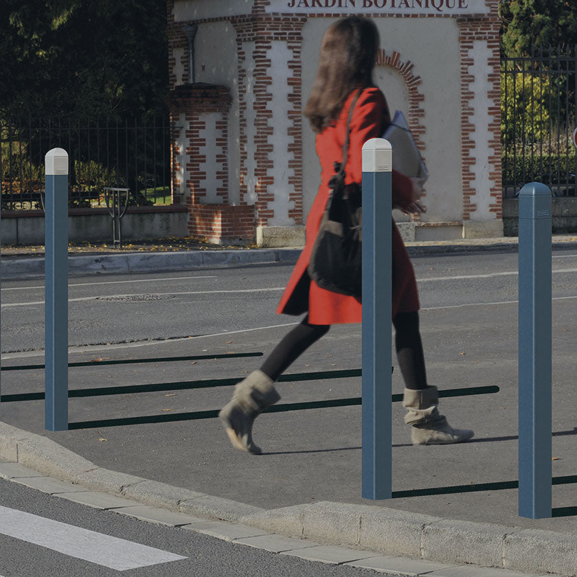 Steel street bollards protecting a passing pedestrian