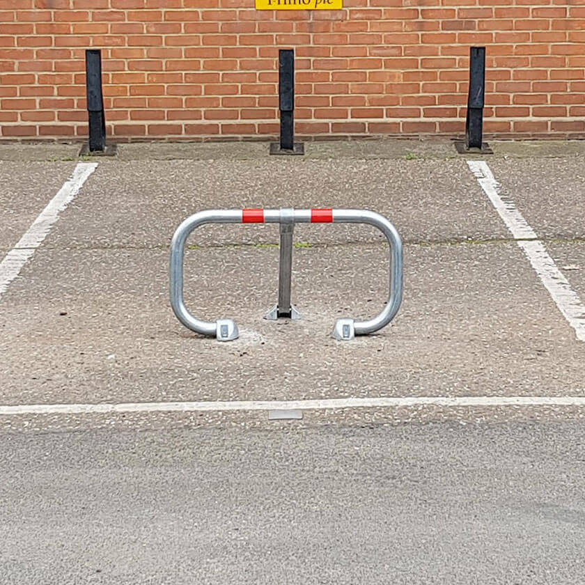 City fold down parking barrier protecting a car parking space.