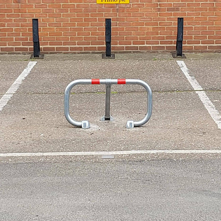 City fold down parking barrier protecting a car parking space.