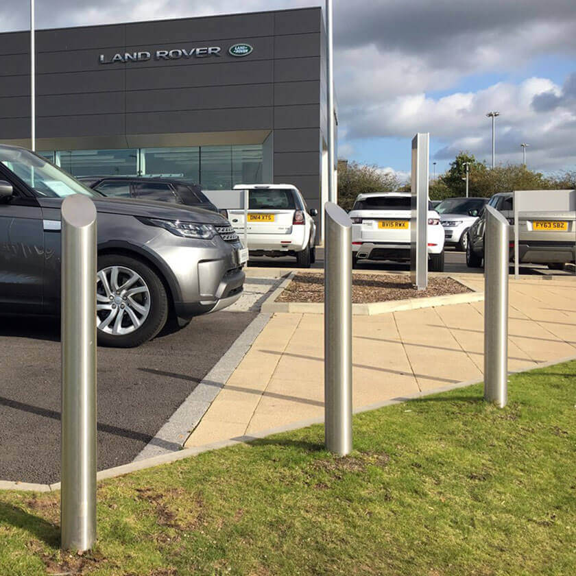 Mitre top stainless steel bollards on a vehicle forecourt
