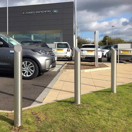 Mitre top stainless steel bollards on a vehicle forecourt