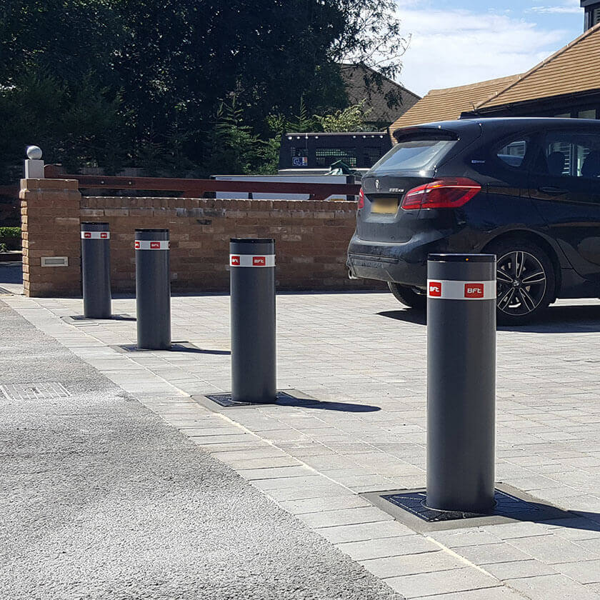 Automatic rising bollards installed across the entrance of a block paved driveway