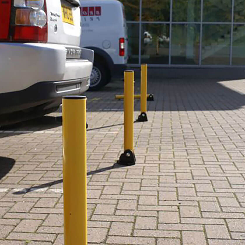 Row of yellow parking posts in a car park 