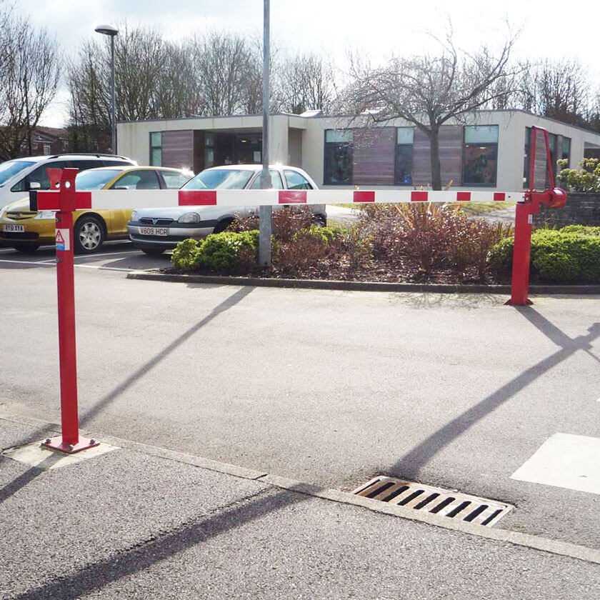 Manual lift arm barrier protecting a private car park