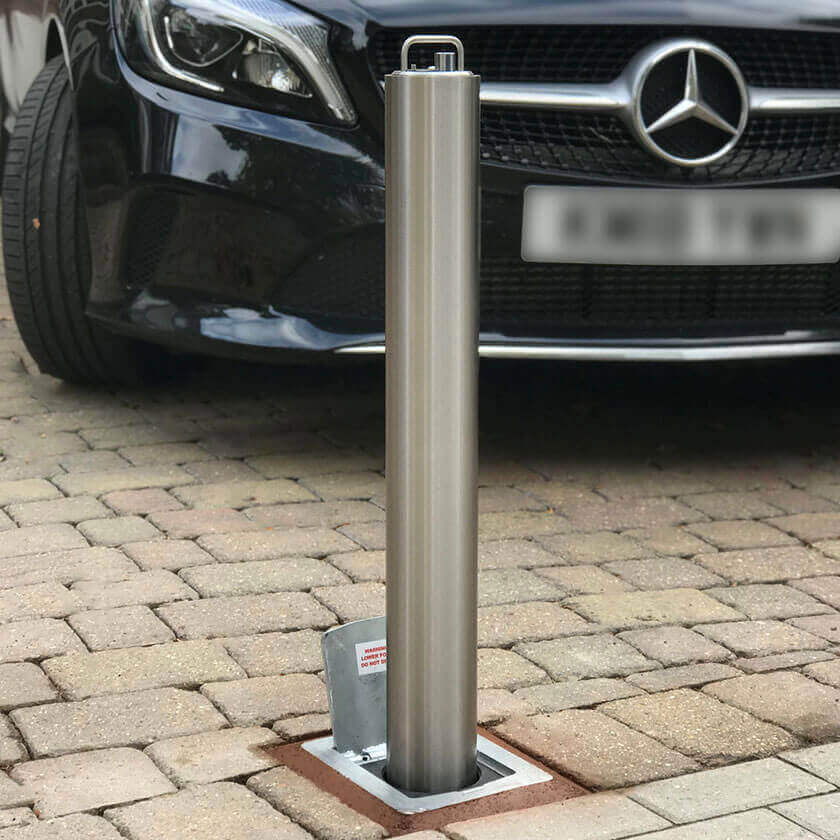 Stainless steel telescopic bollard on a block paved driveway