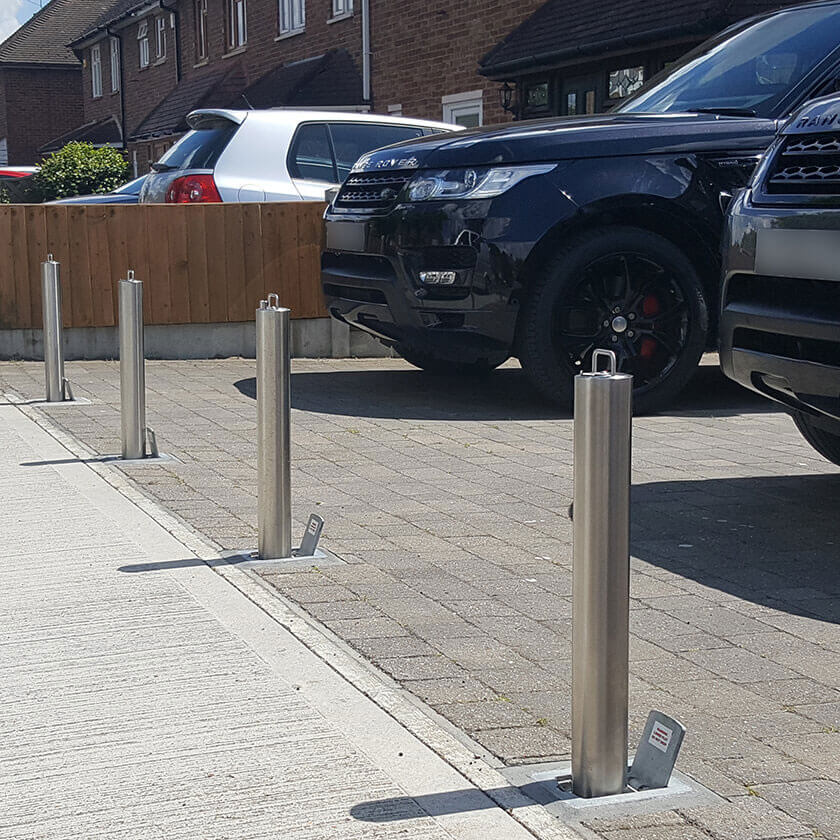 Stainless steel telescopic bollards installed across the entrance of a driveway