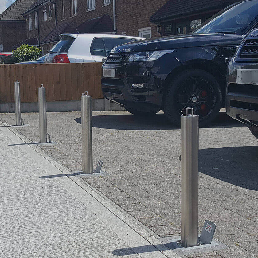 Residential high-security telescopic bollards installed across the entrance of a driveway