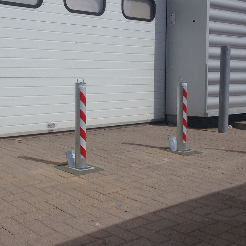 Heavy duty, reinforced telescopic security bollards installed to protect roller shutters from an attempted ram raid attack