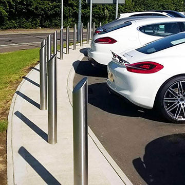 Stainless steel fixed bollards protecting the perimeter of a vehicle forecourt