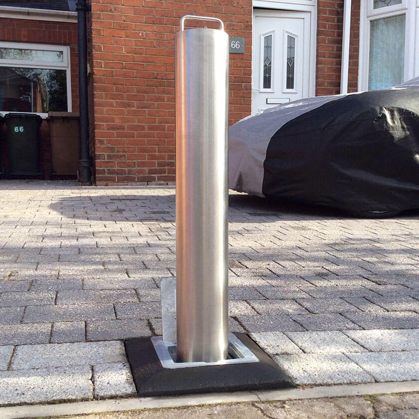 Stainless steel lift assisted telescopic bollard on a private driveway.
