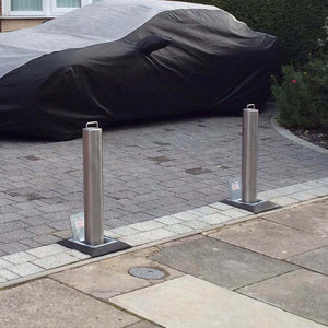 Stainless steel lift assisted telescopic bollards on a private driveway.